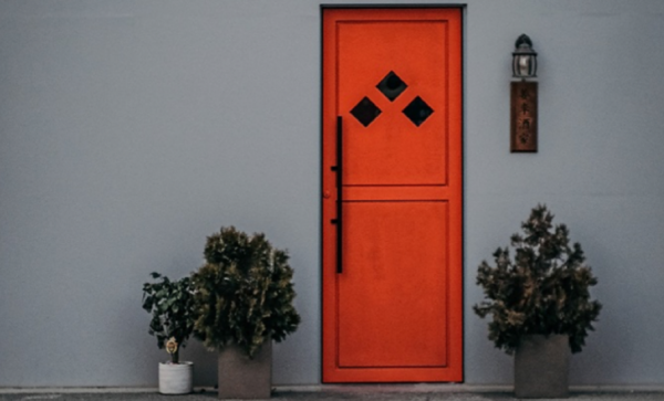 Pintu rumah dengan aksen logam bertekstur